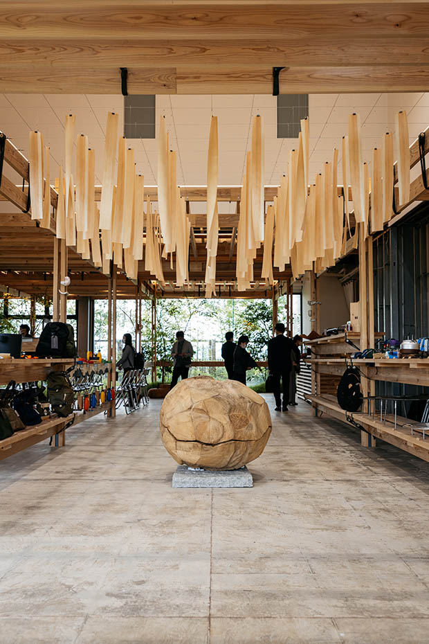 福岡在住の彫刻家・新庄良博さんによる作品（中央）。さまざまな木の素材を生かしたインテリアが出迎える。